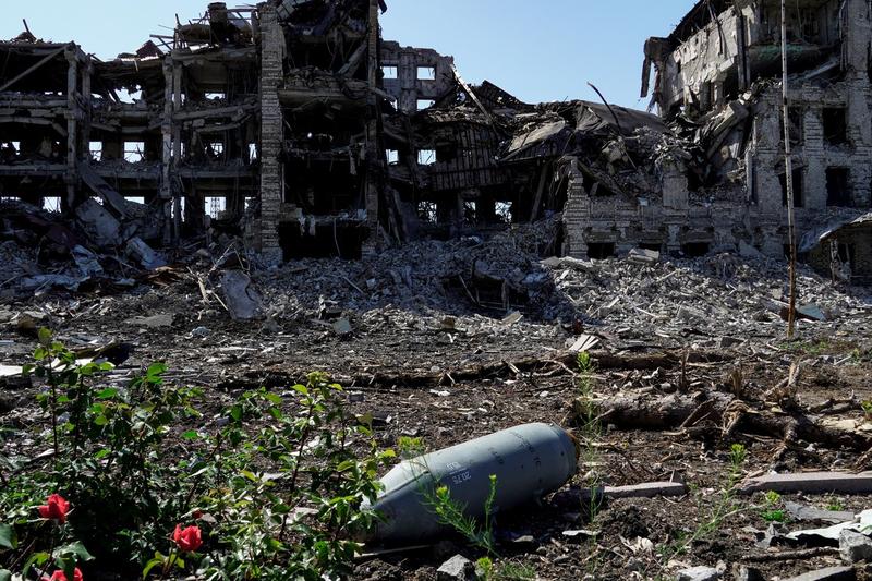 O bombă neexplodată în fața unei clădiri distruse din Mariupol, Ucraina