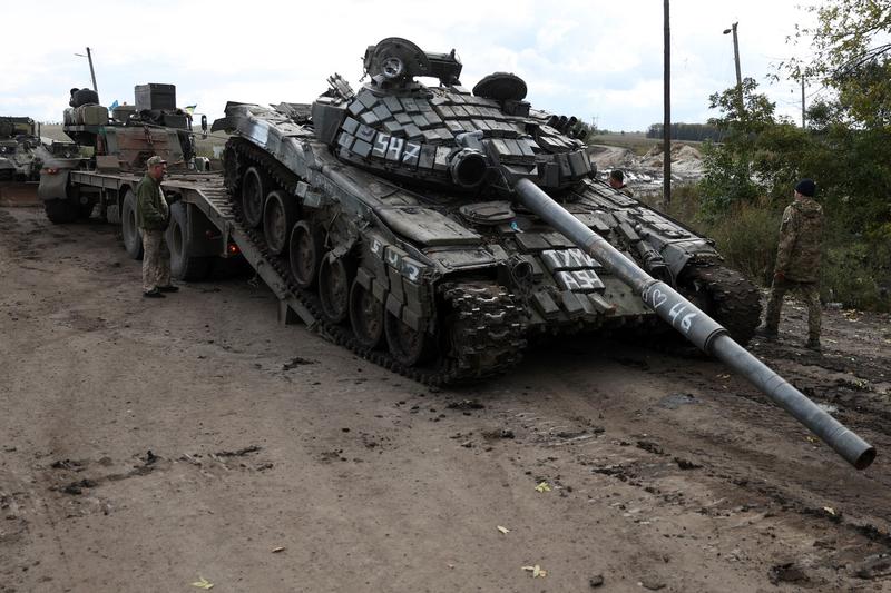 Un tanc rusesc T-72 este încărcat pe un camion de către soldații ucraineni în afara orașului Izium