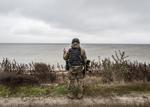 Gest sfidător al unui soldat ucrainean de pe malul eliberat al fluviului Nipru, în regiunea Herson