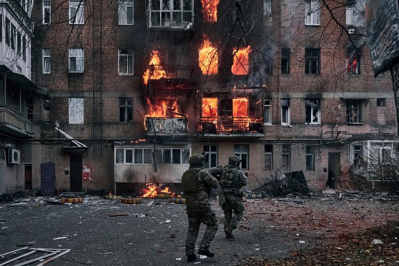 Soldați ucraineni fug să ajute oameni dintr-un apartament în flăcări după bombardamentele rusești în Bahmut