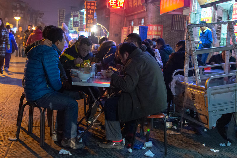 Chinezi luând masa pe stradă în orașul Luoyang din provincia Henan
