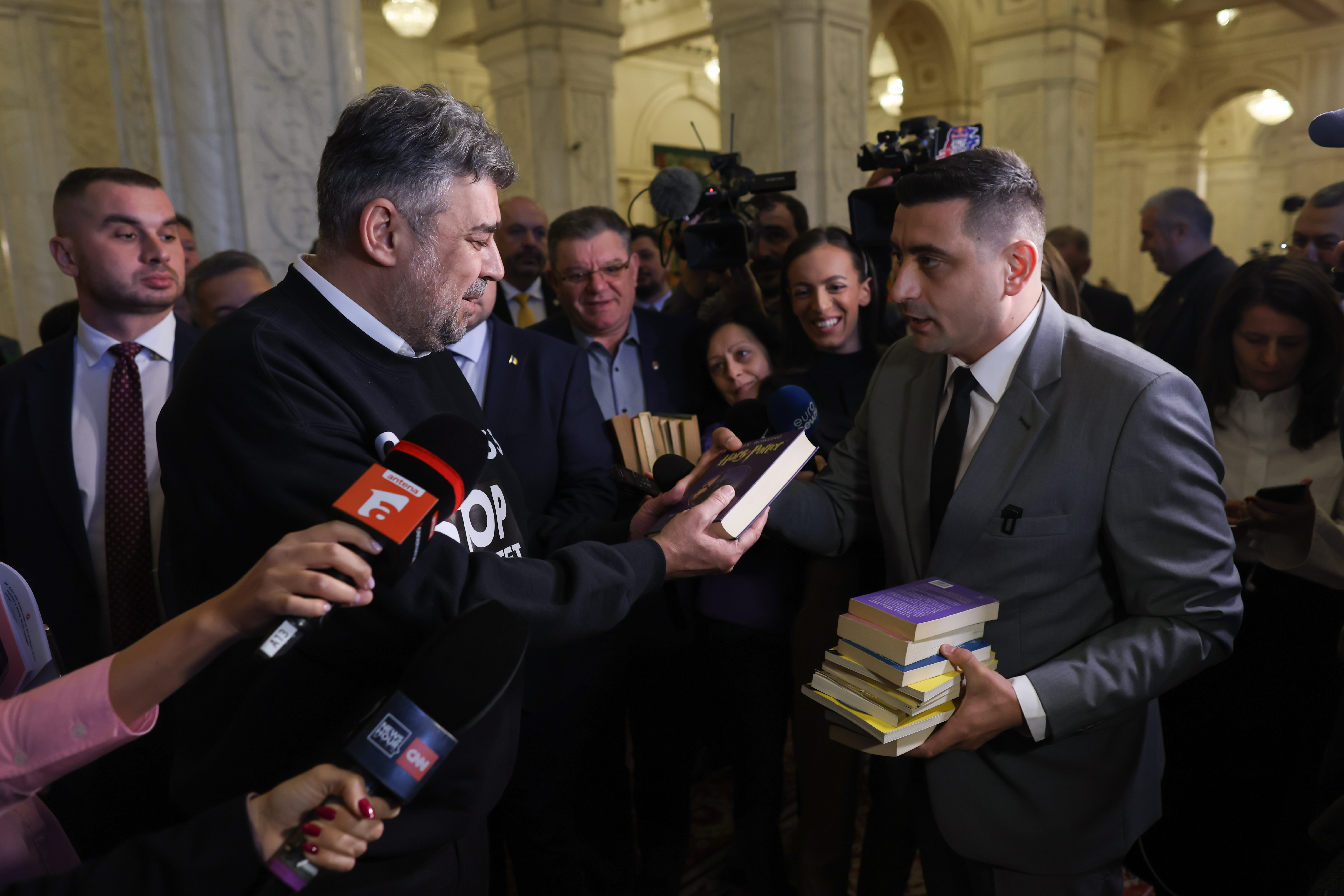 Prima reacție a lui Marcel Ciolacu în scandalul cu înjurături Simion - Simonis / Liderul AUR i-a dat premierului o carte cu Harry Potter