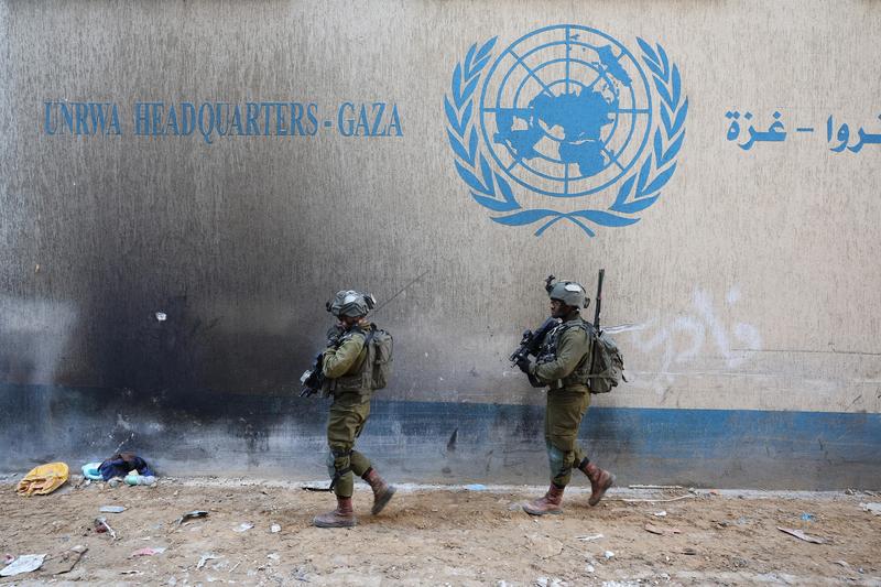 Soldati israelieni in fata unei cladiri evacuate a UNRWA, agentia ONU pentru palestinieni, din Fasia Gaza