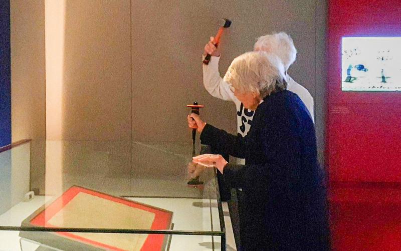 Activistele Sue Parfitt (stânga) și Judy Bruce (dreapta) folosind un ciocan și o daltă în încercarea de a sparge vitrina de sticlă care protejează Magna Carta în Galeria Comorilor de la Biblioteca Britanică din Londra, pe 10 mai 2024.