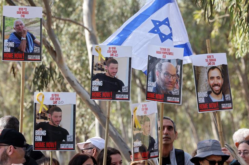 Portretele ostaticilor Gadi Moses, Itay Chen, Nadav Popplewell și Tal Shoham, ținute de rudele lor, înaintea unui marș de patru zile spre Ierusalim, pe 28 februarie 2024.
