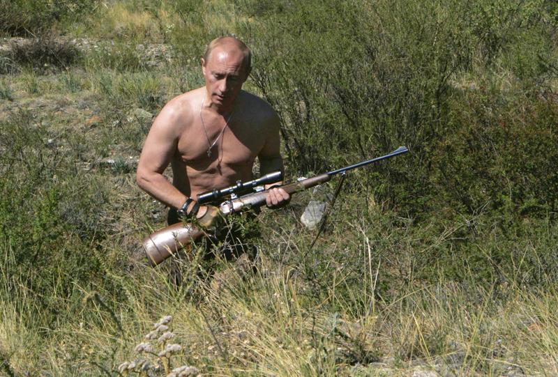 Vladimir Putin, în 2010, cu o armă de vânătoare și cu bustul gol, în regiunea rusă Tuva, la granița cu Mongolia
