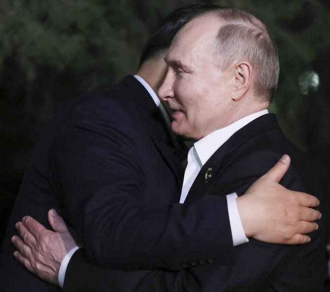 Xi Jinping se imbratiseaza cu Vladimir Putin