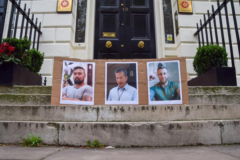 Fotografiile lui Chi Leung Wai, Chung Biu Yuen și Matthew Trickett, bărbații acuzați de spionaj, în timpul unui protest împotriva spionajului  la Londra