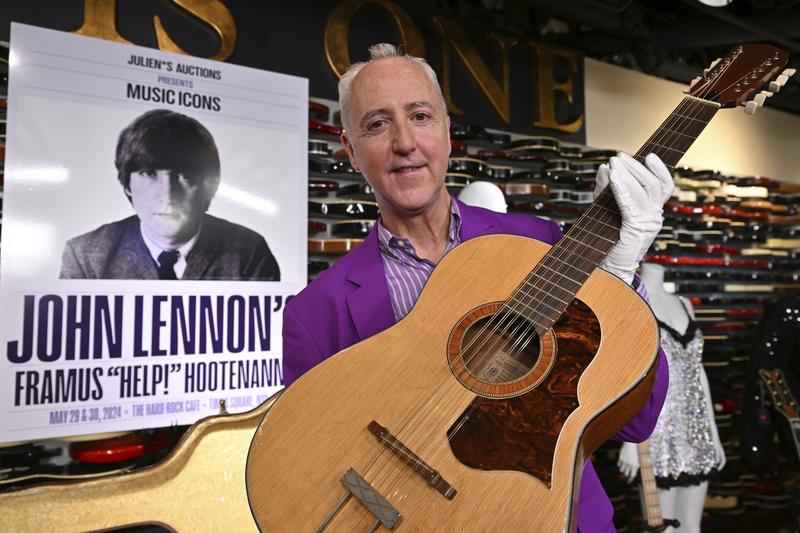 Directorul executiv al casei de licitații Julien's Auctions, Martin J. Nolan, prezintă chitara pierdută a lui John Lennon vândută cu aproape 3 milioane de dolari
