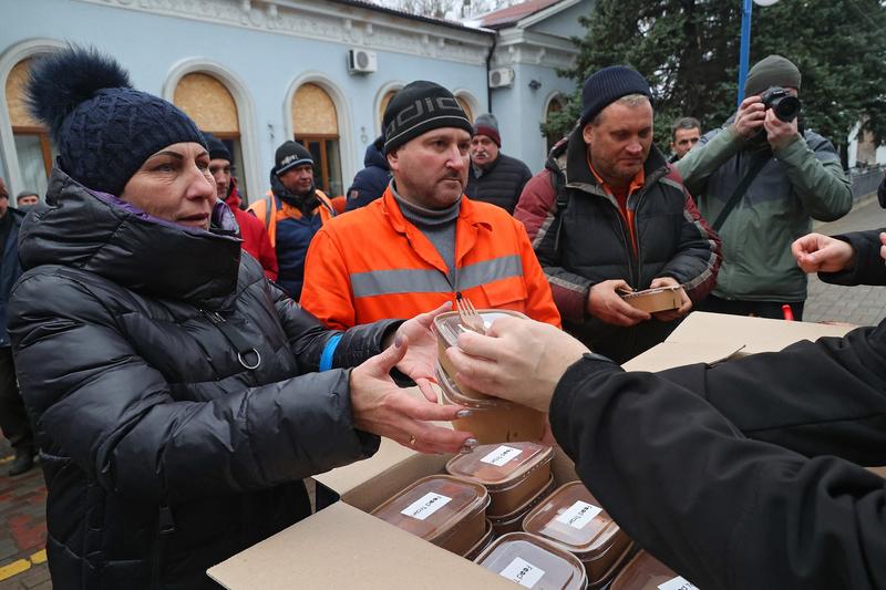 Localnicii primesc mâncare gătită, livrată prin intermediul „Trenului Alimentelor”, în gara din Izium, regiunea Harkov, din nord-estul Ucrainei, 24 noiembrie 2023
