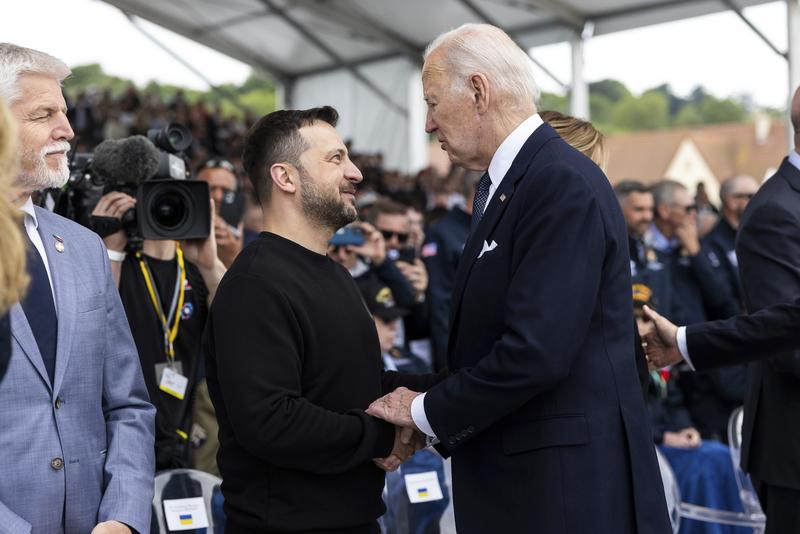 Volodimir Zelenski îl salută pe președintele american Joe Biden,	 la Memorialul Omaha Beach, 6 iunie 2024, în Saint-Laurent-sur-Mer, Normandia, Franța.